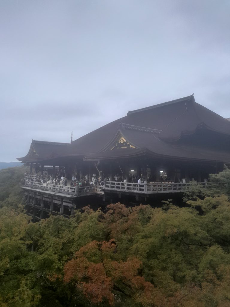 Vue panoramqie du temple Kiyomizu-dera à Kyoto avec sa grande terrasse en bois sur pilotis dominant la forêt.