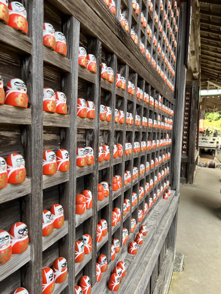 Etagères en bois remplies de centaines de petites figurines Daruma rouges au temple Katsuo-ji à Osaka, Japon
