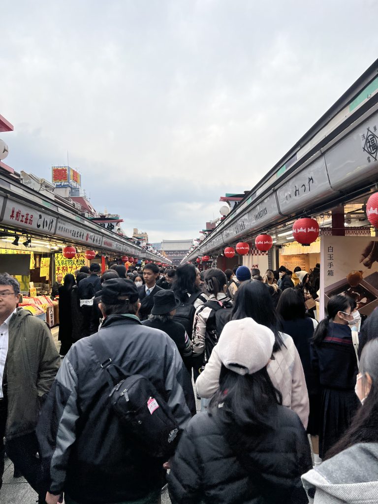 Foule dense de visiteurs marchant dans la rue commerçante Nakamise-dori vers le temple Senso-ji à Asakusa, Tokyo